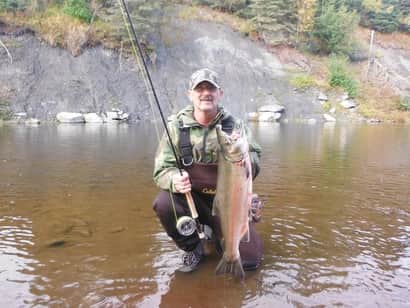 A successful Fly fisherman with a Coho Salmon